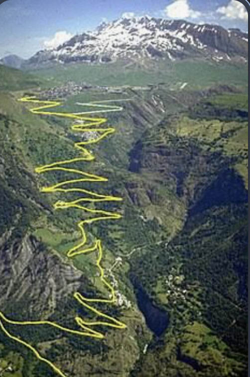 Aerial view of Alpe d'Huez with the 21 hairpin switchbacks highlighted in yellow on the mountainside